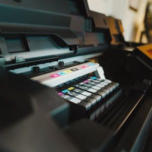 Detailed view of ink cartridges inside a digital inkjet printer in an office setting.